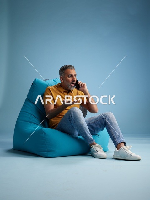 Saudi Man Talking on Mobile Phone Sitting on Bean Bag