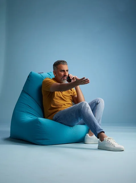 رجل سعودي يتحدث بالهاتف جالساً على بين باق