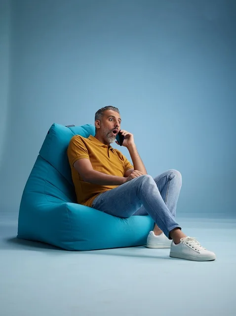 Surprised Saudi Man on Phone Sitting on Beanbag