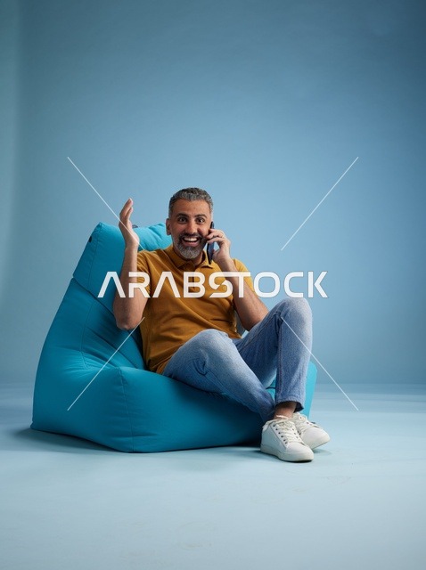 Saudi Man Talking on Mobile Phone Sitting on Bean Bag