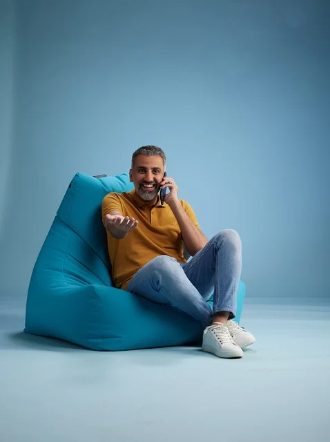 رجل سعودي يتحدث بالهاتف على كرسي بين باق