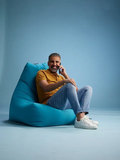 رجل سعودي على كرسي بين باق يتحدث عبر الهاتف الذكي