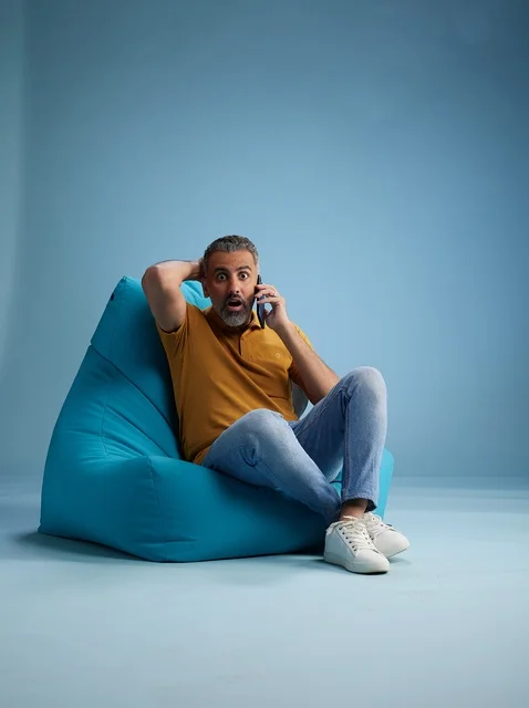 رجل سعودي مصدوم يتحدث بالهاتف على كرسي بين باج