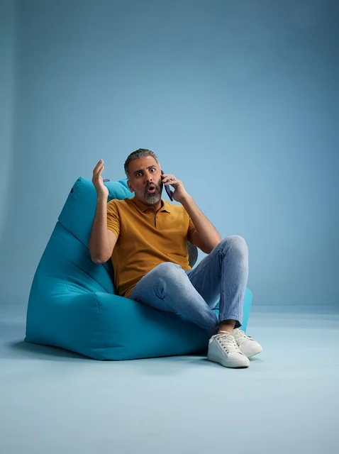 Surprised Saudi Man on Bean Bag Talking on Phone