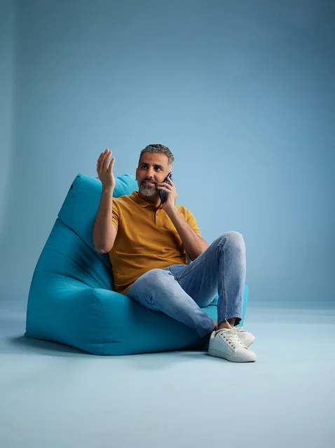 رجل سعودي يتحدث بالهاتف على كرسي بين باج