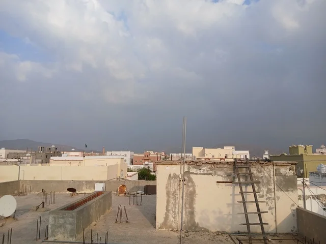 أسطح المنازل السكنية الحضرية والجبال تحت سماء غائمة