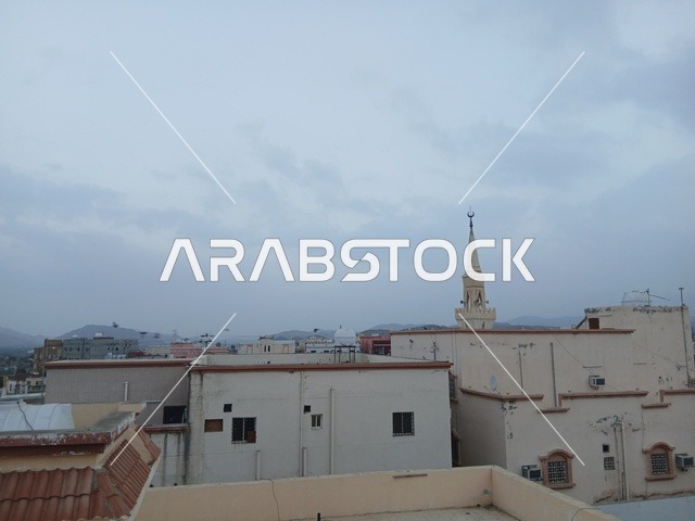 مئذنة مسجد ومباني سكنية في بلدة جدة التاريخية تحت سماء غائمة