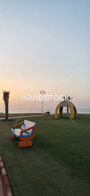مقعد ومنتزه عام على الساحل وقت غروب الشمس بالسعودية
