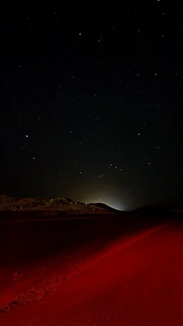 سماء الليل المرصعة بالنجوم في الصحراء مع رمال حمراء