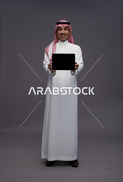 Saudi Man in Traditional Dress Holding Digital Tablet