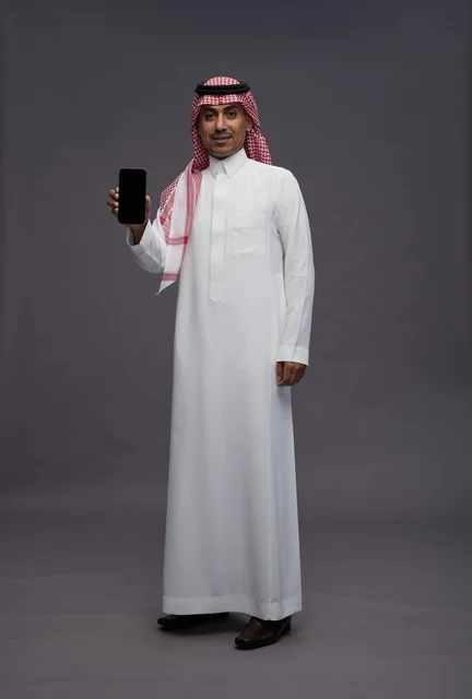 Saudi Man in Traditional Thobe Holding Blank Smartphone