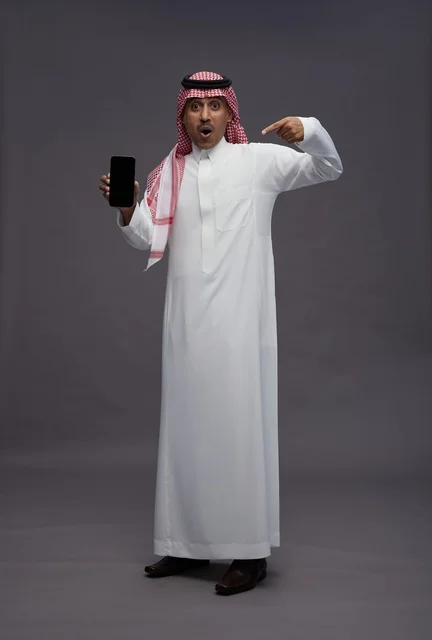 Saudi Man Pointing at Smartphone with Shocked Expression