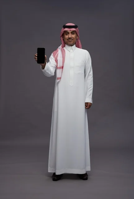 Saudi Man in Traditional Thobe Holding Blank Smartphone