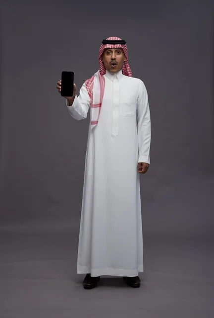 Surprised Saudi Man Holding Smartphone With Blank Screen