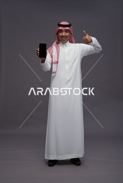 Saudi Man Holding Smartphone with Thumbs Up Gesture