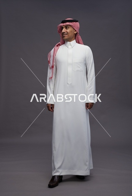 رجل سعودي بالثوب التقليدي على خلفية رمادية