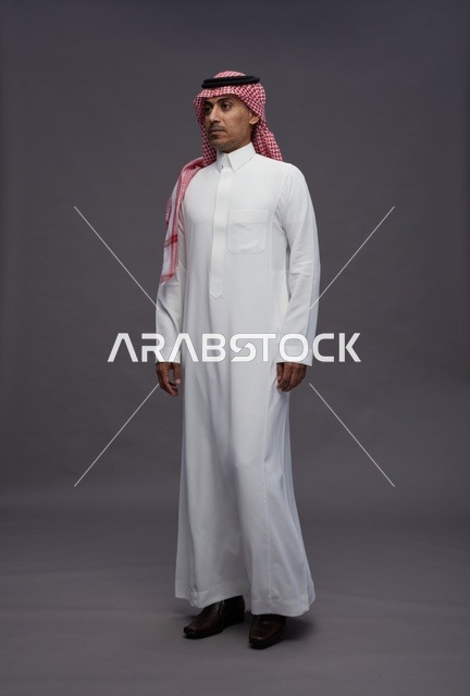 رجل سعودي بالثوب التقليدي في خلفية استوديو