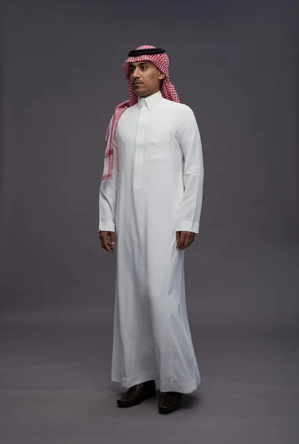 رجل سعودي بالثوب التقليدي في خلفية استوديو