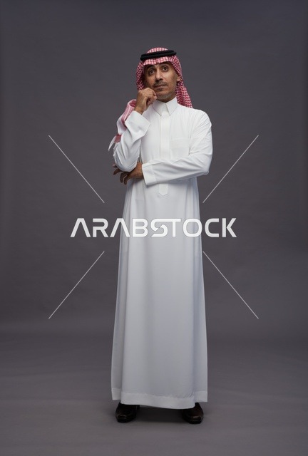 رجل سعودي بملابس تقليدية يفكر في استوديو تصوير