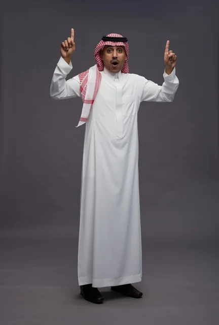 Saudi Man in Thobe Pointing Up with Surprised Expression
