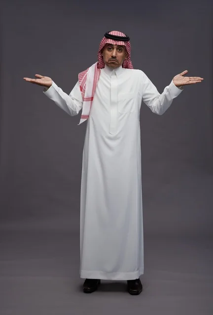 رجل سعودي بالزي التقليدي يرفع ذراعيه بحيرة