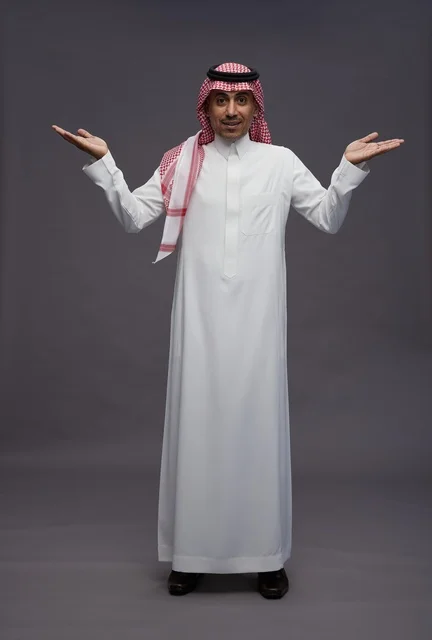 رجل سعودي بالثوب مع إيماءة تقديم باليد