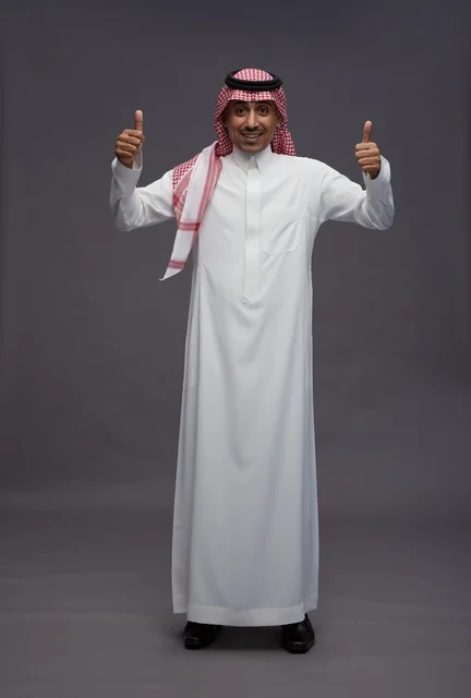 رجل سعودي بالزي التقليدي يشير بعلامة الإعجاب