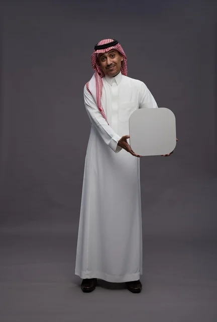 Saudi Man Holding Blank White Board on Grey Background