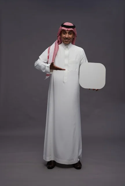 رجل سعودي يحمل لوحة بيضاء فارغة للإعلانات