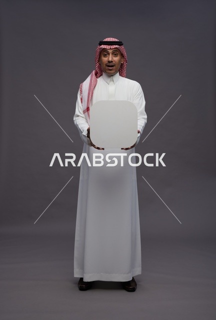 رجل سعودي مندهش يمسك لوحة بيضاء فارغة