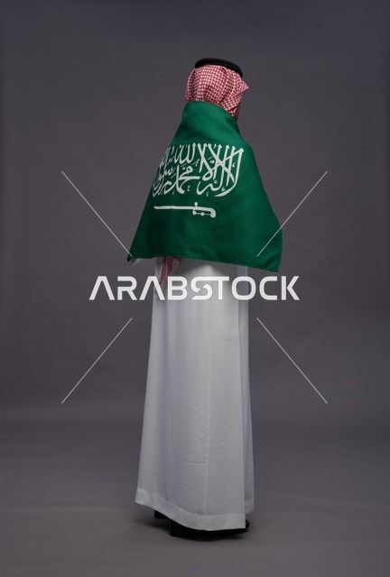 رجل سعودي بالعلم من الخلف في استوديو