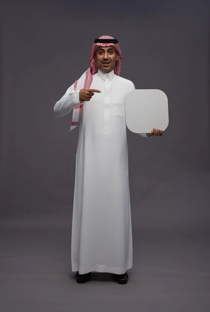 Saudi Man in Traditional Dress Pointing at Blank Sign