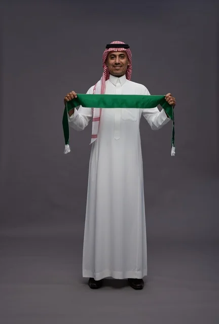 رجل سعودي يحمل وشاح المملكة في الاستوديو