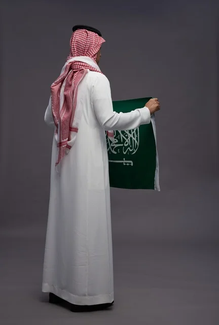 رجل سعودي يحمل علم المملكة العربية السعودية من الخلف رجل سعودي يحمل علم المملكة العربية السعودية من الخلف