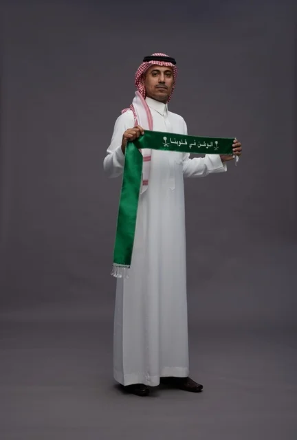 رجل سعودي يحمل وشاح اليوم الوطني السعودي في استوديو