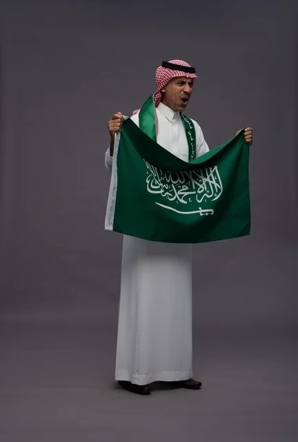 رجل سعودي يحمل علم المملكة العربية السعودية