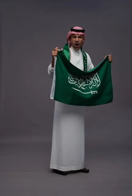 رجل سعودي يحمل علم المملكة العربية السعودية