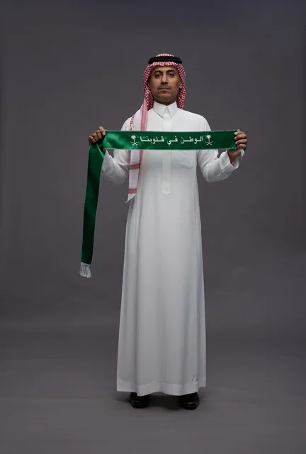 Saudi Man in Traditional Thobe Holding National Scarf