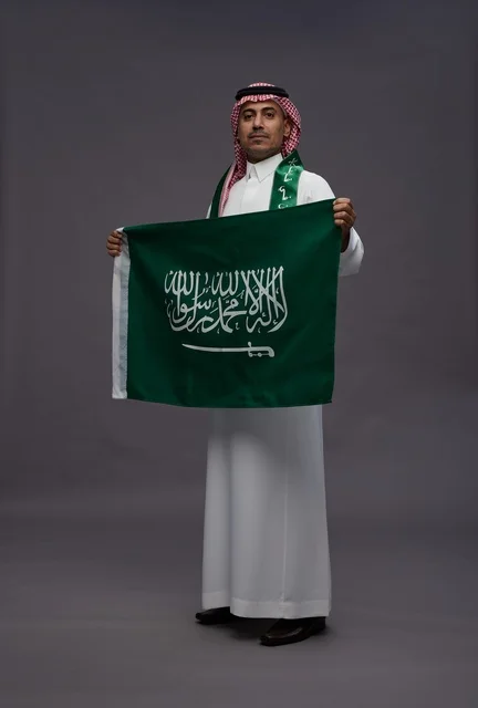 Saudi Man Holding Saudi Arabia Flag in Studio