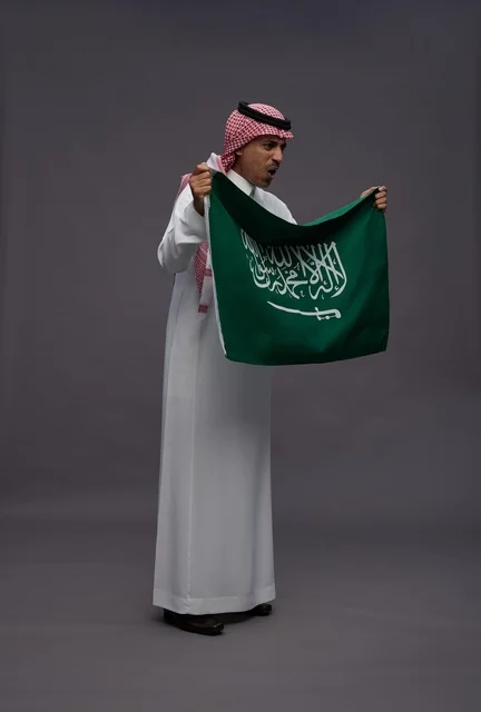 رجل سعودي يحمل علم المملكة العربية السعودية