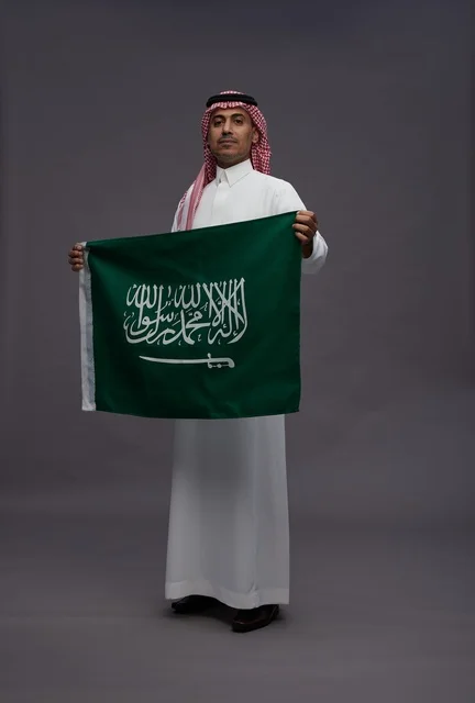 رجل سعودي يحمل علم المملكة العربية السعودية