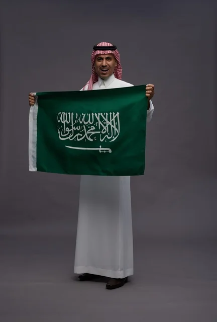 رجل سعودي يحمل علم المملكة العربية السعودية