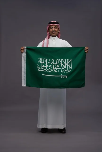 Saudi Man Holding Saudi Arabia Flag in Studio