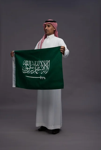رجل سعودي يحمل علم المملكة العربية السعودية