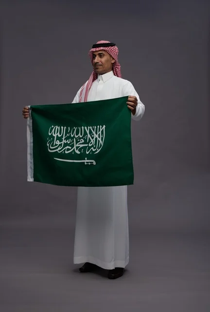 رجل سعودي يحمل علم المملكة العربية السعودية