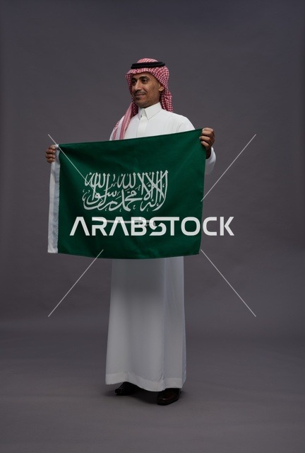 رجل سعودي يحمل علم المملكة العربية السعودية