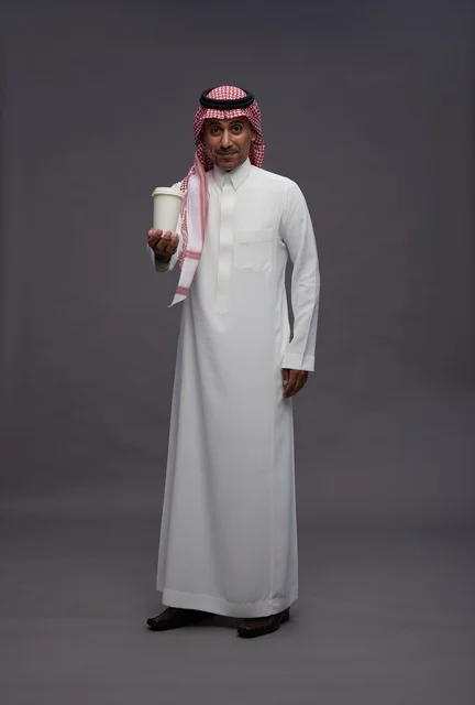 Saudi Man in Traditional Dress Holding Coffee Cup