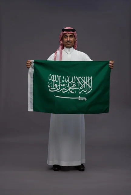 Saudi Man Holding Saudi Arabia National Flag in Studio