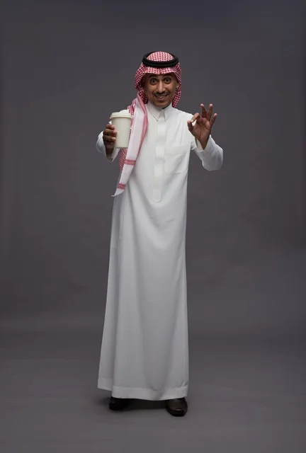 Saudi Man in Traditional Dress with Coffee Cup