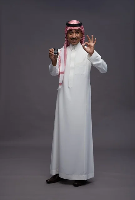 رجل سعودي بالزي التقليدي يحمل مفتاح سيارة
